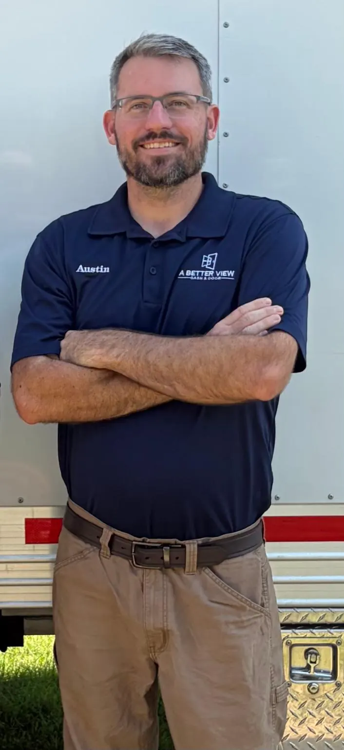 Austin Boyd smiling with arms crossed, wearing a navy A Better View Sash & Door polo with his name stitched on it.